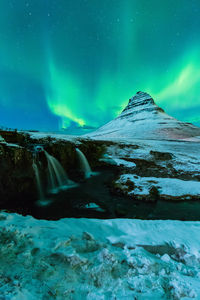 Scenic view of snowcapped mountains against sky at night