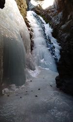 Scenic view of frozen river flowing through rocks