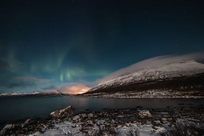 Scenic view of snowcapped mountains against sky at night