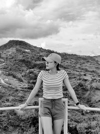 Rear view of young woman standing against mountain