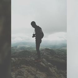 Man standing on mountain against sky