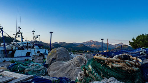 Fishing net at harbor against clear blue sky