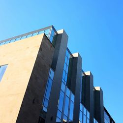 Low angle view of skyscraper against clear blue sky