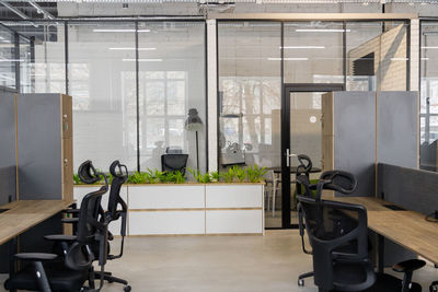 Interior of modern coworking space without people, containing tables and chairs.