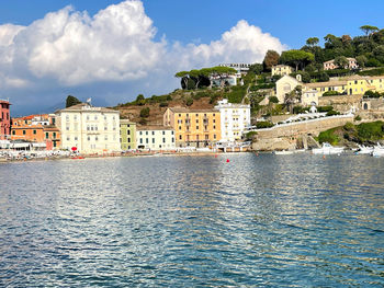 Buildings by sea against sky in city