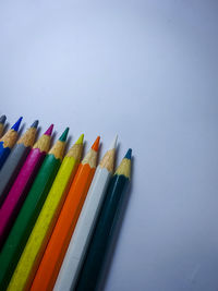 High angle view of colored pencils against white background