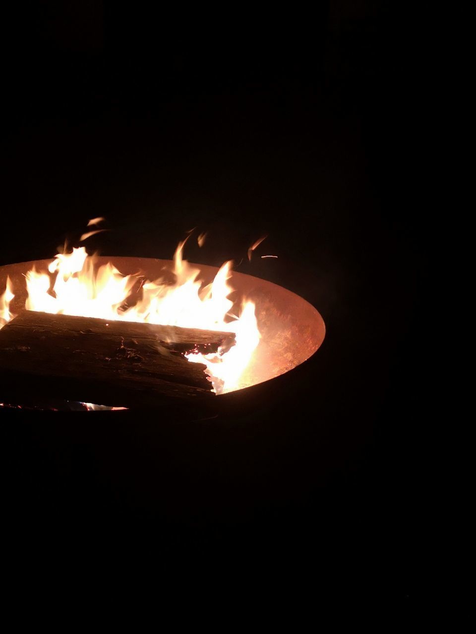 CLOSE-UP OF FIRE IN THE DARK AGAINST BLACK BACKGROUND