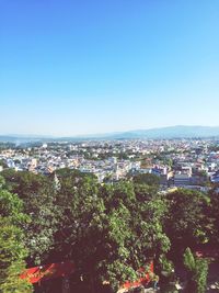 Aerial view of cityscape against clear blue sky