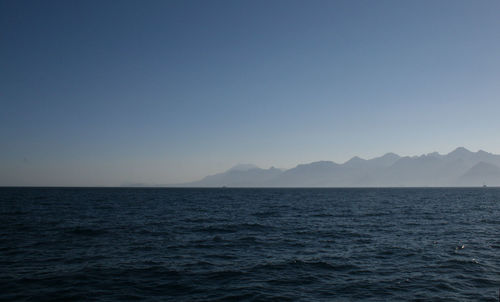 Scenic view of sea and mountains against sky