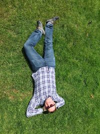 Directly above shot of smiling mid adult man lying on grassy field