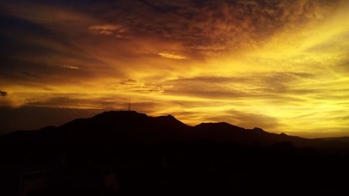 Scenic view of silhouette mountains against dramatic sky