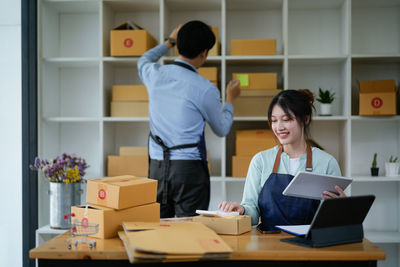 Side view of young woman using laptop while standing in office