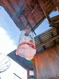 Low angle view of lanterns hanging by building against sky