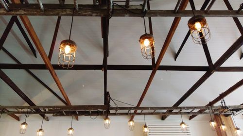 Low angle view of illuminated pendant light hanging from ceiling