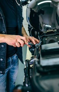 Midsection of man holding camera while standing in car