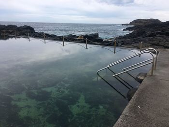 High angle view of swimming pool by sea against sky