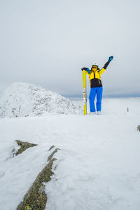 Rear view of woman skiing on snow covered landscape