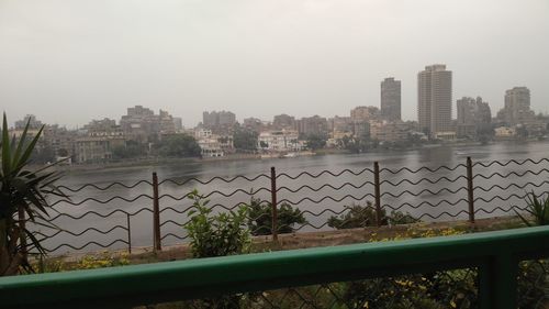 River by buildings against sky in city