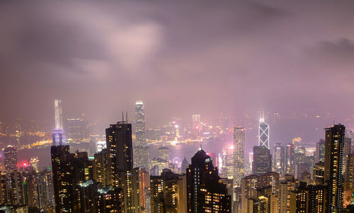 Illuminated modern buildings in city against sky