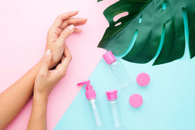 High angle view of woman hand holding pink over white background