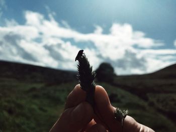 Close-up of person holding stick against sky