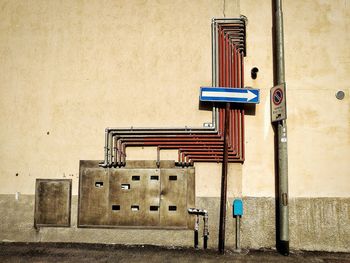 Pipes and road sign by building