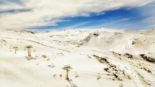 Aerial view of snowcapped mountain against cloudy sky