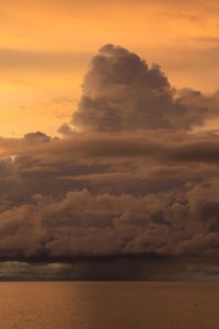 Scenic view of sea against dramatic sky during sunset