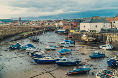 High angle view of boats moored on beach by buildings in city