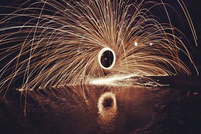 Wire wool at lakeshore against sky at night