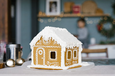 A beautiful gingerbread house with a close-up glaze, stands on the table in the kitchen