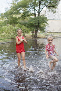 Full length of mother and girl enjoying in water