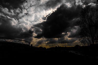 Silhouette landscape against cloudy sky