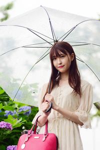 Portrait of young woman holding umbrella