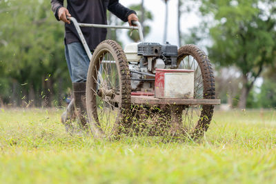 Thai worker mowing grass with machine in the public garden