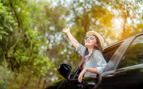 Young woman smiling while sitting in car