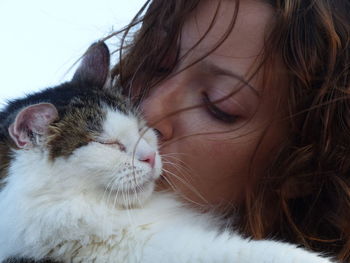 Close-up portrait of woman with cat with eyes closed