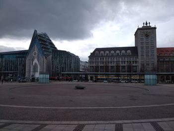 Buildings in city against cloudy sky