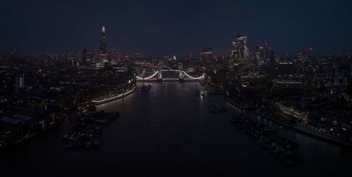 Aerial view to the illuminated tower bridge and skyline of london, uk