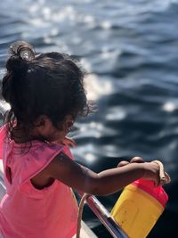 Rear view of girl with arms raised in water