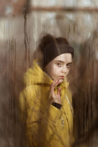 Portrait of young woman in glass window