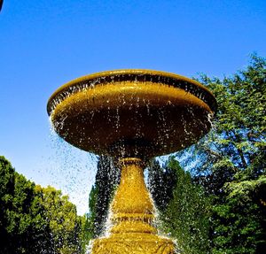 Low angle view of trees against clear blue sky