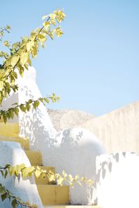 Low angle view of snowcapped mountains against clear blue sky