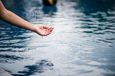 Cropped hand by lake