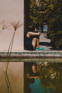 Man sitting by swimming pool in lake