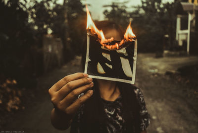 Close-up of hand holding burning fire