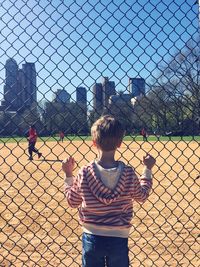 Man standing on chainlink fence