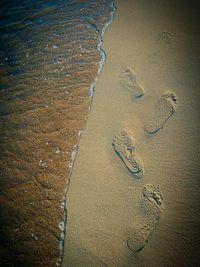 High angle view of footprints on sand at beach