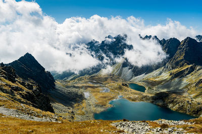 Scenic view of lake by mountains against sky