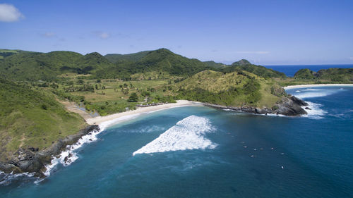 Scenic view of sea and mountains against clear blue sky